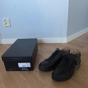 Svarta sneakers från Giuseppe Zanotti - Säljer ett par svarta sneakers från Giuseppe Zanotti i mycket bra skick. Skorna har en cool stänkmönsterdesign i grått och är gjorda av skinn. Köpta från deras egna hemsida. Nästan nyskick