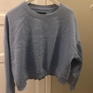 Ljusblå sweatshirt från 157 - Säljer en supermjuk och bekväm ljusblå sweatshirt från 157. Perfekt för kyliga dagar med sin avslappnade passform och ribbade muddar vid ärmslut och nederkant. Passar både till vardags och mysiga hemmakvällar. 🩵