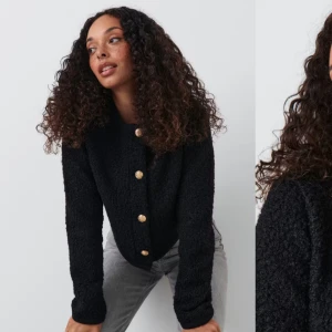 Svart stickad jacka med guldknappar från Gina tricot  - Säljer en snygg svart stickad jacka med guldknappar framtill. Den är croppad och har långa ärmar, perfekt för höst och vår. Jackan är i mycket bra skick och passar både till vardags och fest. Jackan är helt oanvänd då den inte passade just mig så den är i jättefint skick.