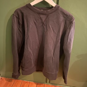 Blågrå långärmad tröja från ARKET - Säljer en blågrå långärmad tröja från Arket i bra skick. Perfekt för höst och vinter med sin enkla och stilrena design. Tröjan har en rund hals och ribbade muddar vid ärmslut och nederkant. Passar både till vardags och mysiga hemmakvällar.