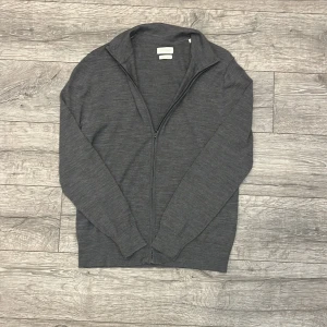 Grå merinoulltröja från These Glory Days - Säljer en stilren grå tröja i merinoull från These Glory Days. Perfekt för både höst och vinter med sin mjuka och varma känsla. Tröjan har en dragkedja framtill och långa ärmar, vilket gör den både praktisk och snygg. Passar lika bra till vardags som till lite finare tillfällen. | Skick 9/10 | Storlek M | 100% Merinoull | Hör gärna av dig vid fler frågor! 😊