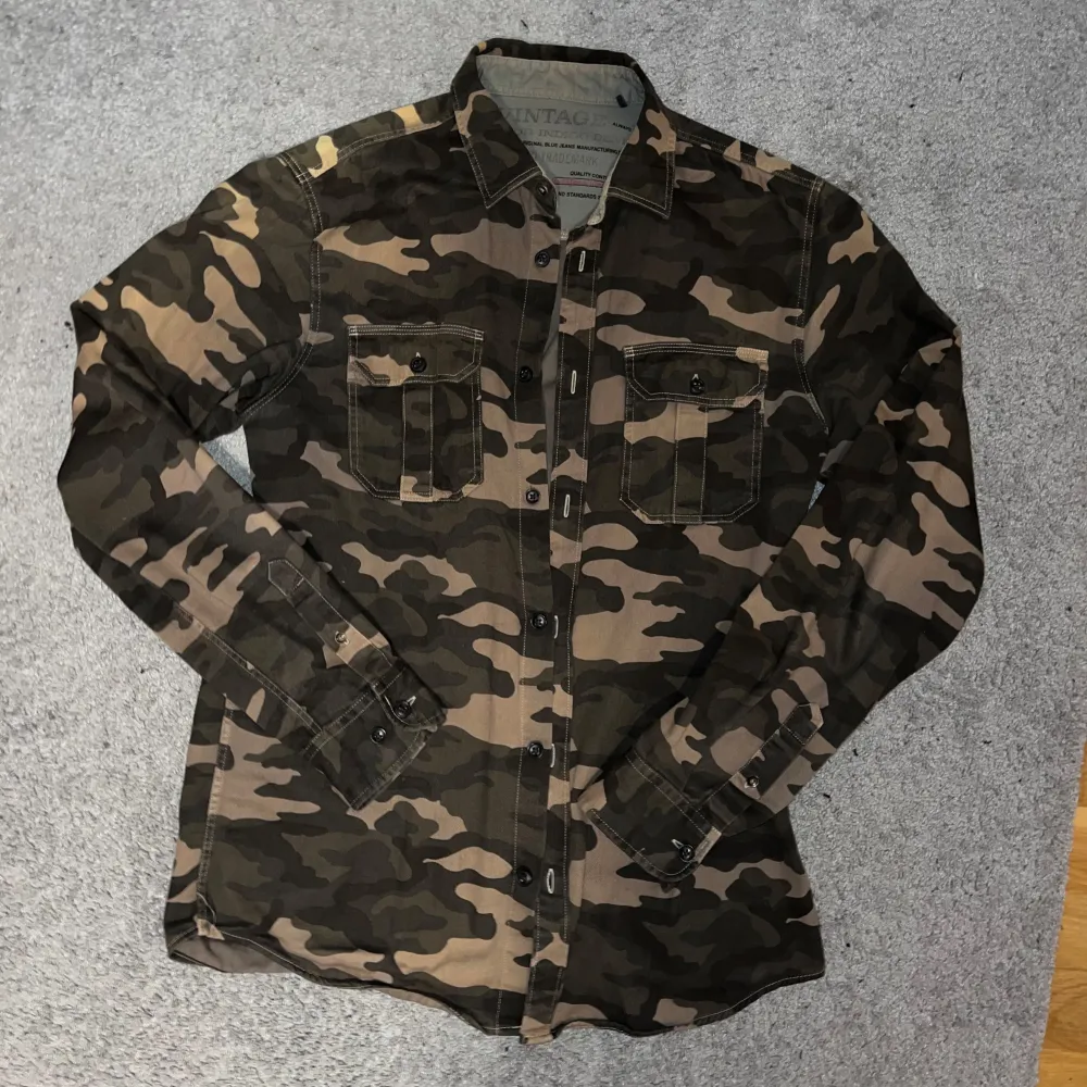 Väldigt sällsynt Jack&Jones vintage Collective camo overshirt!! Passar som storlek S!! Finns bara några exemplar. Den är i jeans material ! Skriv vid frågor och funderingar.. Jackor.