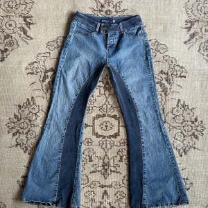 Lågmidjade bootcutjeans med bootcut detaljer - Supercoola lågmidjade utsvängda 70-tals/00-tals inspirerade jeans med blåa Manchester detaljer‼️Skulle säga bootcut/ flared ben💖 känn er fria tt komma med bud om ni vill💋