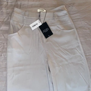 Grå/beige figursydda byxor från 4th & reckless  - Säljer ett par snygga figursydda byxor från 4th & reckless tall i storlek 36. De är helt nya med lappar kvar. Har en stilren design. Perfekta för både vardag och fest! 🕶️ 98 % polyester 2 % elastan. Har legat i mitt förråd om det luktar. 