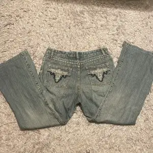 Supersnygga midwaist wide/bootcut jeans med broderade fickor. Innerbenslängd: 63 cm Midjelängd: 36 cm tvärs över Fråga om fler bilder Priset kan diskuteras