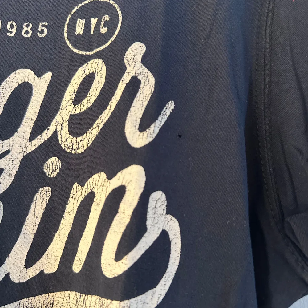 Tommy Hilfiger t-shirt med tryck. Trycket är lite slitet (se bild 2) och sedan har tröjan ett litet litet hål (se bild 3) annars hel och ren. Storlek M. T-shirts.