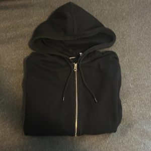 Svart Zip-hoodie - Svart zip-hoodie från weekday. Är i XS men är ganska stor i storleken så jag skulle säga att den är S.