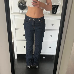 Mellanmidjade raka jeans - Säljer dessa supersnygga mellanmidjade jeans ifrån Weekday! Storlek 28/32 i en mörkblå färg med fina detaljer. Lite långa på mig som är 164 cm lång!