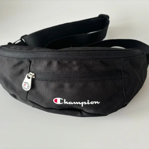 Champion Midjeväska/Beltbag - Midjeväska ifrån champion🌟 Helt oanvänd. Ett stort fack samt tvä mindre ytterfack. Justerbar crossbody-rem😇