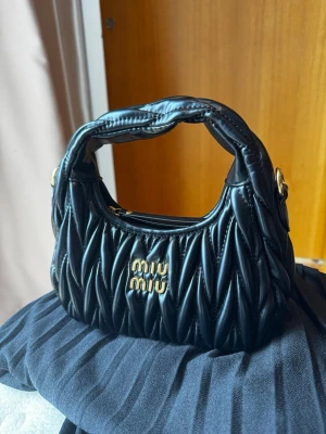 Miu Miu väska - Helt ny Miu Miu väska aldrig använd i quiltat läder. Tror inte den är äkta, men den är iaf helt ny med dustbag och identisk till dem riktiga! Med dustbag och lapp