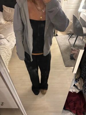 Ljusgrå zip hoodie med huva - Säljer en ljusgrå hoodie med dragkedja och huva. Hoodien har två fickor framtill och en avslappnad passform. Perfekt för chill dagar och enkel att matcha med olika outfits. Materialet känns mjukt och bekvämt.