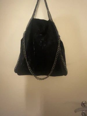 Svart axelväska  -  Jättefin axelväska med silverkedjor som är perfekt storlek för att få plats med mycket och perfekt om man vill ha en fin stilren väska , perfekt till våren och sommaren