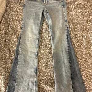 Ljusblå utsvängda jeans H&M - Säljer ett par ljusblå jeans med breda utsvängda ben och hög midja. Jeansen har klassisk femficksdesign, bälteshällor och en cool tvättad look. Perfekta för dig som gillar retrostil och vill sticka ut med en unik siluett.