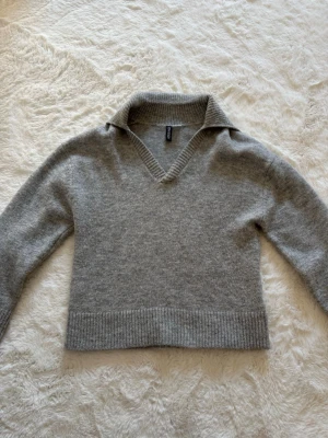 Grå stickad tröja  - Mysig grå stickad tröja från H&m med v-ringning i oversized modell, storlek XXS. Aldrig använd, så i nyskick. 