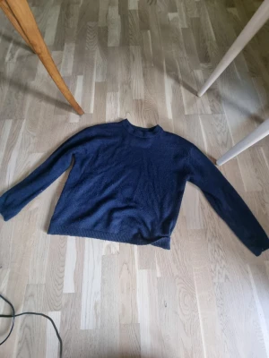 Mörkblå stickad tröja från lager 157 - Mysig mörkblå stickad tröja från lager 157 med enkel design och rund hals. Tröjan har långa ärmar och ribbade muddar vid hals. Strl 160