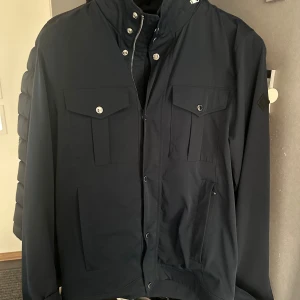 J Lindberg Field Jacket - En otroligt snygg och trendig Field jacka från J Lindberg i färgen navy blue. Jag bär kläder i M men denna jacka är i storlek S och passar mig perfekt. Modellen heter Bailey poly jacket. Nyköpt för 3400kr säljer för 2500kr. Priset går att diskuteras, kom privat för fler frågor.