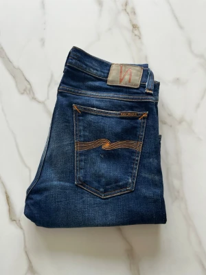Nudie Jeans - Säljer ett par riktigt feta Nudie jeans i storlek W31/30. Jeansen har en sjukt snygg design och är i fint skick, 9/10. Hör av dig vid frågor eller funderingar🙌✅
