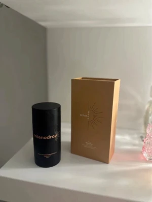 TAN drops  - Flytande foundation från Milano Drop i en snygg brun glasflaska med pipett. Kommer i en elegant guldig förpackning. Perfekt för dig som vill ha en naturlig och fräsch bas. Innehåller 50 ml och har en stilren design med svart lock.
