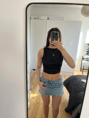 Svart croppad topp med öppen rygg - Snygg svart croppad topp med öppen rygg och knytning i ryggen. 