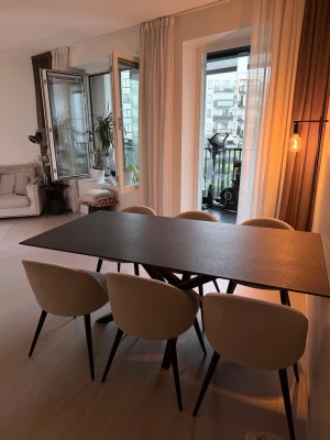 Matbord med sex stolar, svart och beige - Säljer ett modernt matbord med svart rektangulär bordsskiva och sex stoppade stolar i beige tyg. Bordet har stilrena svarta metallben och stolarna har rundad rygg och sits för extra komfort. Perfekt för kök eller matplats.