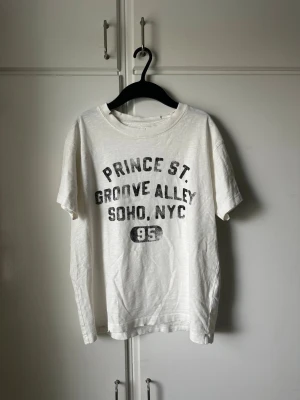 Vit t-shirt med tryck Prince St. - Vit t-shirt från Zara med svart texttryck på bröstet.  Aldrig använd då den inte passar. Passar s/xs