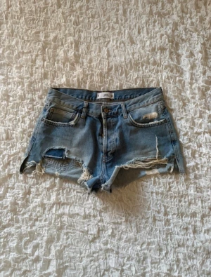 Coola slitna kontrast jeansshorts  - Snygga distressed denimshorts från Mango i storlek 38 (EUR 38 / USA 6). Midjemåttet är 36cm. De har en cool, sliten look med rejäla hål och fransade kanter fram, samt fina slitna detaljer på bakfickorna. Klassisk gylf med knappar. Perfekta till sommaren och festivaler! I mycket fint skick, hör av dig om du undrar något. ✨
