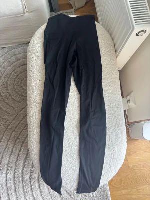 Svarta höga leggings - Säljer ett par svarta leggings med hög midja och lång passform. De är tillverkade i ett stretchigt och mjukt material som sitter tight mot kroppen. Perfekta för en avslappnad och sportig stil. Helt nya aldrig använda