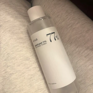 Anua Heartleaf 77% Soothing Toner - En genomskinlig toner från Anua med 77% heartleaf-extrakt. Kommer i en stilren, cylindrisk plastflaska med vit etikett och skruvkork. Perfekt för att lugna och återfukta huden i din dagliga hudvårdsrutin.