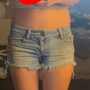 Ljusblå jeansshorts med slitna detaljer  - Jeansshorts från Phink Industries i storlek 152/12. Skulle säga att de passar XXS/XS beroende på hur man vill att de ska sitta. De är i fint skick med slitna detaljer som är en del av designen. Säljer dem eftersom de tyvärr inte passar mig längre. Hör gärna av dig om du vill ha fler bilder eller mått! 