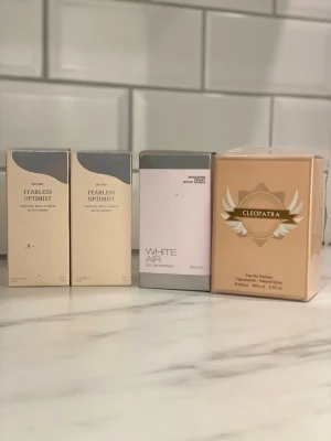 Parfymset med fyra olika dofter - Säljer fyra parfymer i originalförpackning: två Fearless Optimist i beige och grå design, en White Air från Madison Avenue i vit och silver, samt en Cleopatra Eau De Parfum i guldig förpackning med elegant mönster. Perfekt för dig som vill testa nya dofter. ny pris per parfym är 200 kr mitt pris 99 kr
