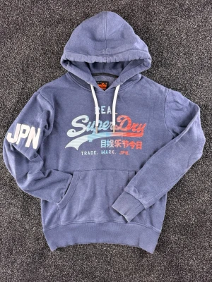 Blå vintage hoodie från Superdry - Blå vintage hoodie från Superdry. Fint skick. Storlek small, men funkar även som medium. Vid frågor är det bara att höra av sig. 