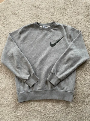 Grå sweatshirt från Nike - Säljer en grå sweatshirt från Nike. Skicket är bra bara använd fåtal gånger! Hör av er vid frågor.                                             OPS! tar emot prisförslag 