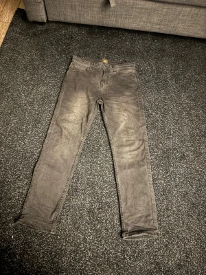 Grå slim fit jeans - Snygga grå slim fit jeans med klassisk femficksdesign och dragkedjegylf. Jeansen har en tvättad look som ger en avslappnad mix. Riktigt najs byxor. W 27 L30