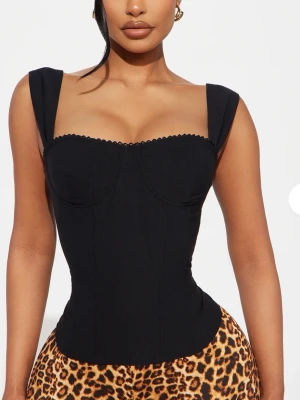 Svart korsett/topp från fashionnova  - Svart fest topp med en fina detaljer från fashionnova . Säljer då den va för stor för mig , den är helt ny och aldrig använd. 