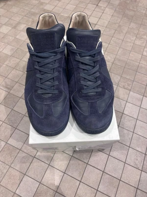 Skor från maison margiela  - Tjena, säljer dessa snygga mörkblå sneakers från Maison Margiela. Skorna är i bra skick och extremt stilrena Box följer med vid köp. Om du har mista fråga så är det bara att skriva🙌