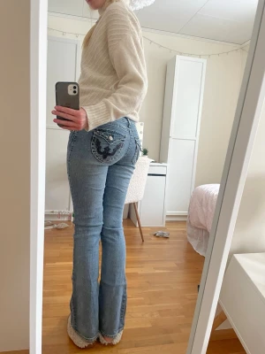 Blå bootcut jeans med coola fickor - Säljer ett par ljusblå bootcut jeans med as snygga fickor. Midjemåttet är 37 cm och innerbenslängden är 78-79 cm