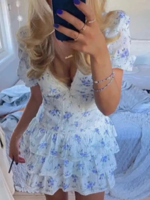 Vit blommig kortklänning  - Vit blommig klänning säljer pågrund av att den är för kort på mig som är väldigt lång. Lånade bilder. 