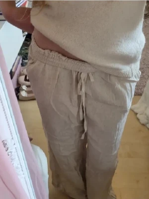 Beiga linnebyxor från nelly - Jag säljer ett par snygga beiga linnebyxor från Nelly i storlek 152. Byxorna är pösiga, har rak passform, medelhög midja och elastisk midja med snörning. De är i mycket bra skick. OBS. Det står på lappen att de är i storlek 32, men jag har sytt upp de så att de passar mig som är 152 cm och vanligtvis har storlek 152 i byxor! Nypris runt 300 kr. Det är bara att skriva om ni är osäkra på längden. 💓
