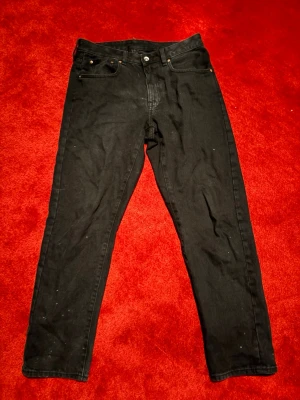 Svarta raka jeans - Säljer ett par svarta jeans med rak passform och klassisk femficksdesign. Jeansen har knappgylf och bälteshällor. Materialet är denim i bomull och de har en enkel, stilren look som passar till det mesta. Märke:valient 