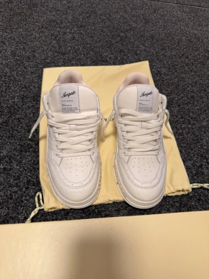 Vita Axel Arigato sneakers - Axel Arigato sneakers i storlek 41.  Skorna levereras med tygpåse och originalkartong enligt bilder.  Använda 4 gånger nypris 3750:- 