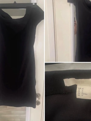 Svart kortärmad klänning - En svart, enkel och stilren kort klänning med korta ärmar och rund halsringning. Klänningen har en rak passform och är tillverkad i ett mjukt material som känns bekvämt mot huden. Perfekt för dig som gillar minimalistisk stil.