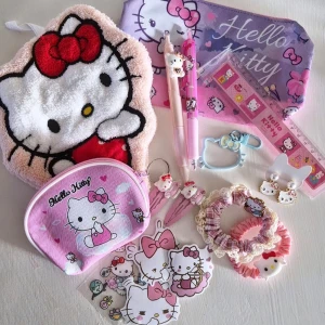 Hello Kitty accessoarset - Ett gulligt Hello Kitty-set med handduk, pennfodral/necessär,  myntbörs,  örhängen,  klistermärken, hårsnoddar, pennor, nyckelring, hårspännen och linjal Allt i rosa, vitt och lila med Hello Kitty-motiv och söta detaljer. Perfekt för dig som älskar kawaii och vill piffa till din vardag.