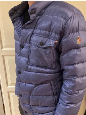 Blå dunjacka med bröstfickor - Snygg blå dunjacka med quiltad design och tryckknappar. Jackan har två bröstfickor med lock, sidofickor och en liten patch på ärmen. Hög krage och modern passform, perfekt för kalla höstdagar samt vinterdagar. Funkar således på sommarkvällar och vårdagar. Från vongreven closet. Vill bli av med samtliga kläder pågrund av flytt så lämna gärna prisförslag!