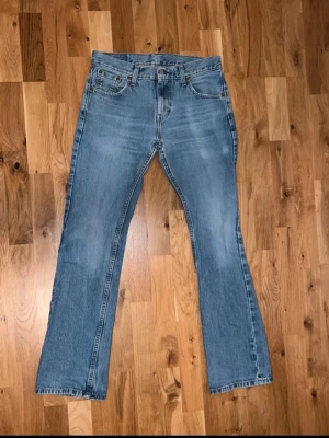 Levis bootcut 527 - Säljer ett par ljusblå Levis 527 bootcut jeans i storlek 29/32 och med klassisk femficksdesign. Jeansen har en liten defekt som syns på sista bilden med det syns inte när man har på de. Vid frågor eller bud är de bara att skriva.