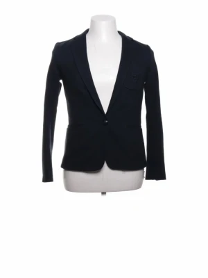 Mörkblå klassisk kavaj - Stilren mörkblå kavaj med smal passform och enkelknäppning. Kavajen har två framfickor och en bröstficka, samt klassisk krage. Perfekt för en dressad look och funkar till både jeans och kostymbyxor.
