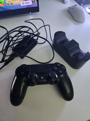 PS4 handkontroll - Säljer en svart trådlös handkontroll till PlayStation 4 med klassisk layout och touchpad. Medföljer laddningsstation och USB-laddningskabel. Perfekt för gaming med bekväma grepp och responsiva knappar i plast. Priset kan diskuteras
