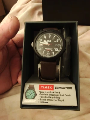 Timex Expedition (svart) - Säljer en Timex Expedition klocka med svart urtavla, tydliga vita siffror och datumvisning. Klockan har ett robust svart boett och ett brunt läder armband från kalv. Perfekt för dig som gillar äventyr och enkel stil. Original armbandet fås med vid önskemål .  