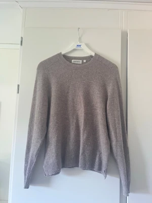 Grå beige stickad tröja Carin Wester - Säljer en grå/beige stickad tröja från Carin Wester i storlek S. Tröjan har rund halsringning, långa ärmar och ribbade muddar vid ärmslut och nederkant. Tröjan har dock ett litet hål på magen och en skada från tvätten som finns på ärmen men detta är inget man lägger märke till  