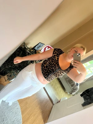 Leopardmönstrad croppad topp - Säljer en croppad topp med leopardmönster och korta ärmar. Toppen har en söt snörningsdetalj framtill och är i stretchigt material som sitter tight. Perfekt för dig som vill sticka ut lite extra.