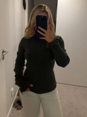 Mörkgrön ribbstickad tröja - Säljer denna superfina gröna, ribbade tröja med vågiga ärmar. Denna tröja är från By Malene Birger och är aldrig använd men lappen är dock borta😊😊